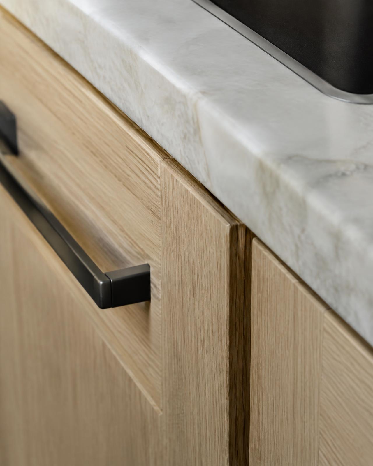 Oak cabinetry and marble countertop detail